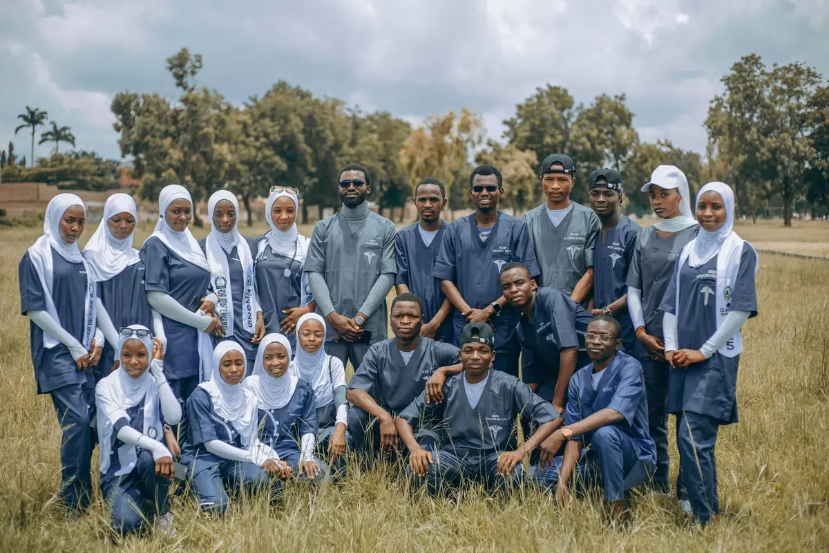 A large group of students in uniforms gathered together outdoors on a field