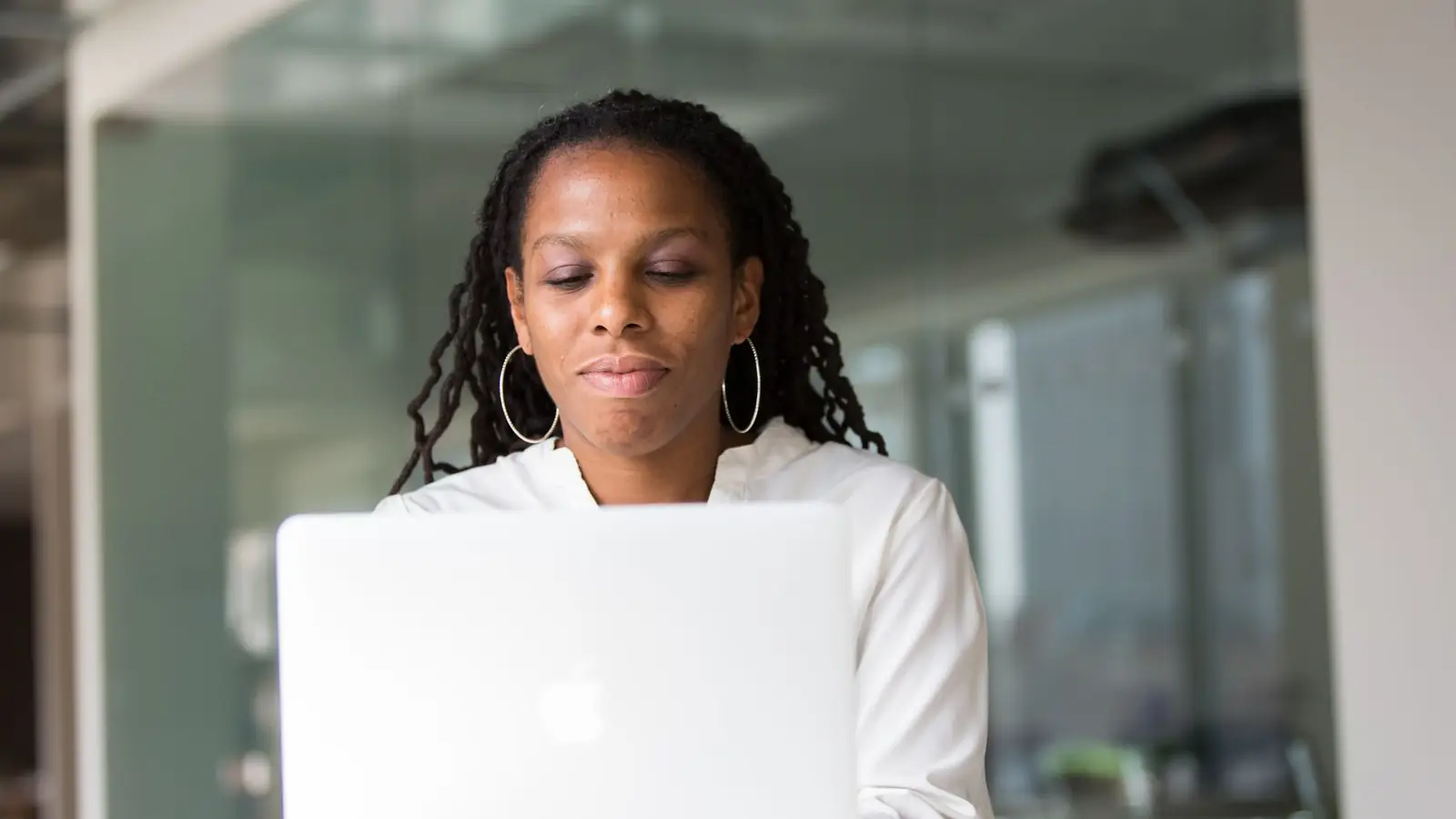 A young woman working on a laptop at a desk