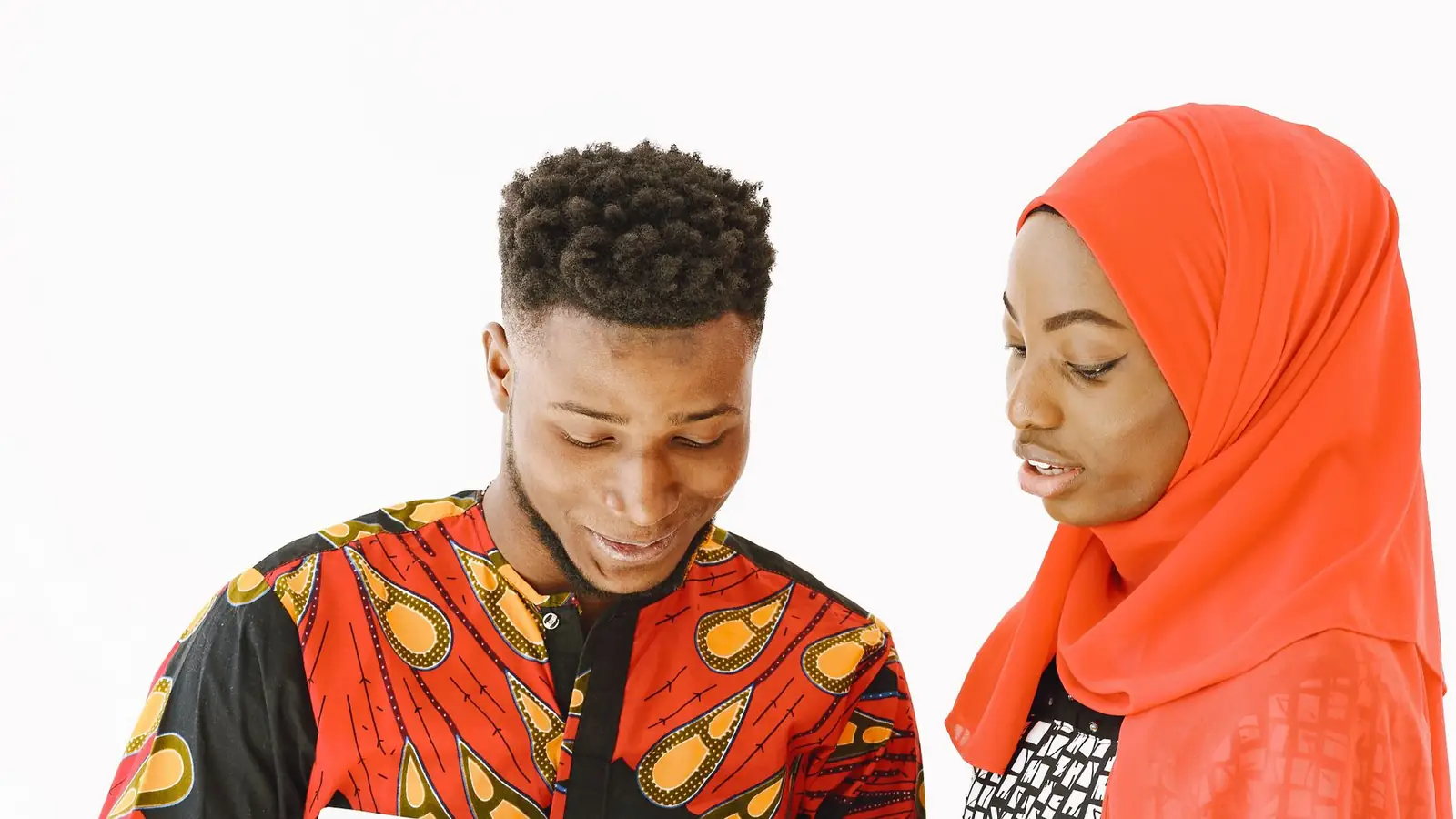 Two students in a studio talking over books