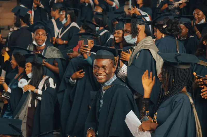 Graduates in gowns and caps celebrating at a university ceremony